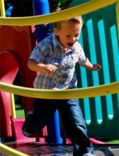 Mobility child running across a playground bridge, symbolizing their mobility