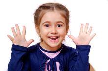 child holding all ten fingers up, representing her understanding of body awareness