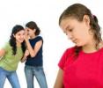 two young girls verbally bullying another young girl
