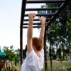 child utilizing their upper body strength on the monkey bars